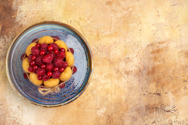多汁新鲜出炉的水果礼品蛋糕在混合色桌子的右侧配料壁板可食用水果