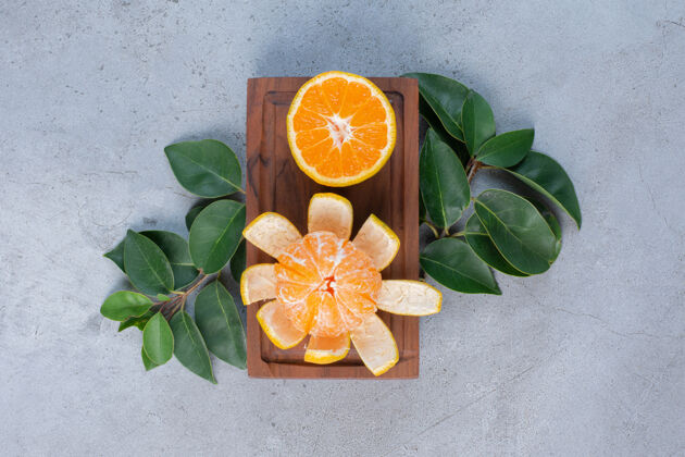 美味在大理石背景的小板上剥皮切橘子水果新鲜天然
