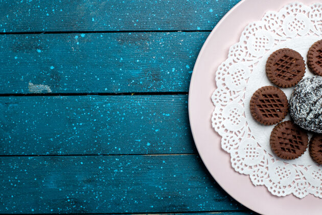 生的俯瞰美味的巧克力曲奇 蓝色乡村桌上有巧克力蛋糕可可茶甜饼干曲奇饼干可可巧克力