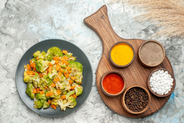 烹饪上图健康蔬菜沙拉不同的调料和切菜板放在白色的桌子上蔬菜一餐豆类