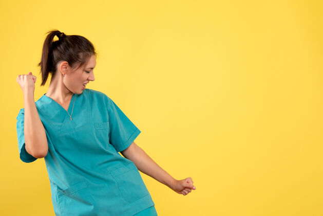 人正面图黄色背景上穿着医用衬衫的女医生欢呼雀跃医疗病毒高兴