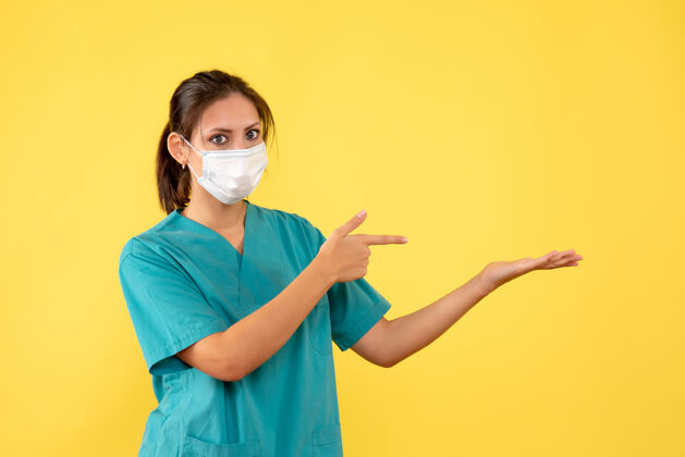 女医生正面图黄色背景上穿着无菌口罩医用衬衫的女医生健康肖像人