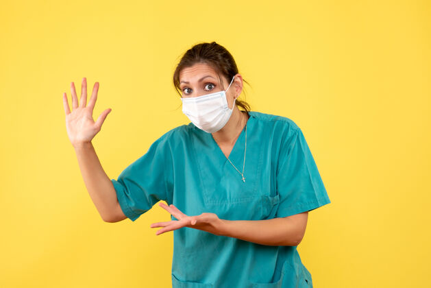 大流行正面图黄色背景上穿着医用衬衫和无菌口罩的女医生面具脸正面