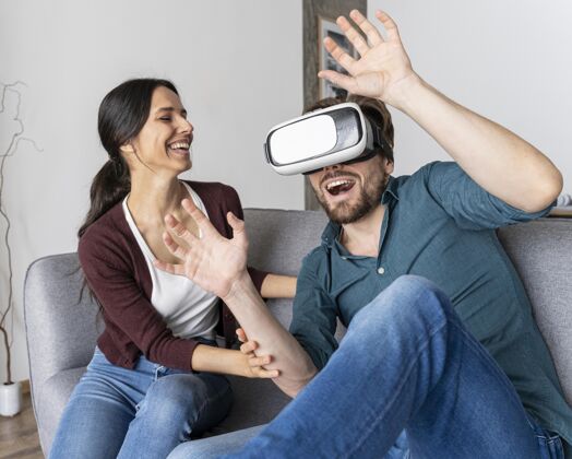 男人男人在家玩虚拟现实耳机旁边的女人男人娱乐水平
