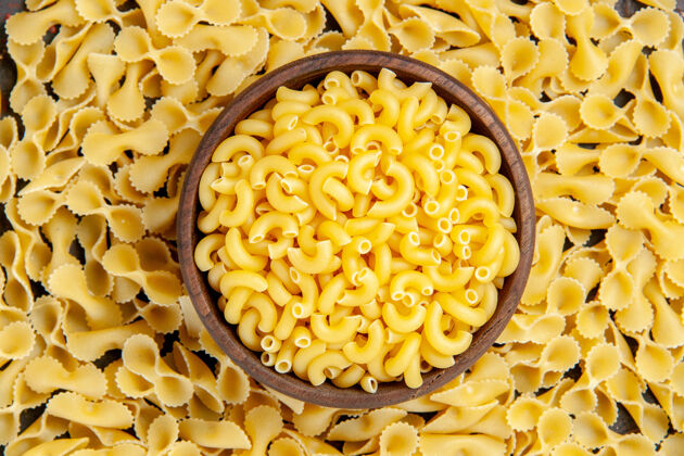 碗蝴蝶未煮熟的意大利面在一个棕色的碗水平视图上混合颜色表高分辨率照片面食食物生的