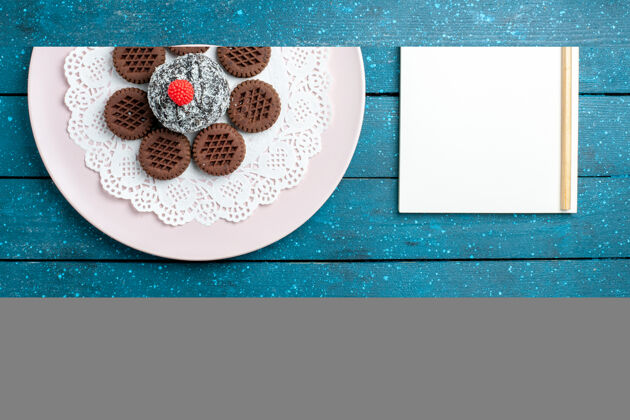 巧克力俯瞰美味的巧克力饼干和巧克力蛋糕放在蓝色的乡村办公桌上饼干茶饼干甜蛋糕糖饼干饼干视图