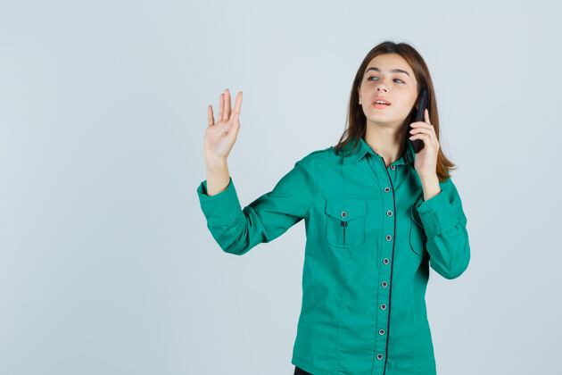 正面一位年轻的女士在讲手机 穿着绿色衬衫 摆出一副很自信的样子正面图女孩手势现代