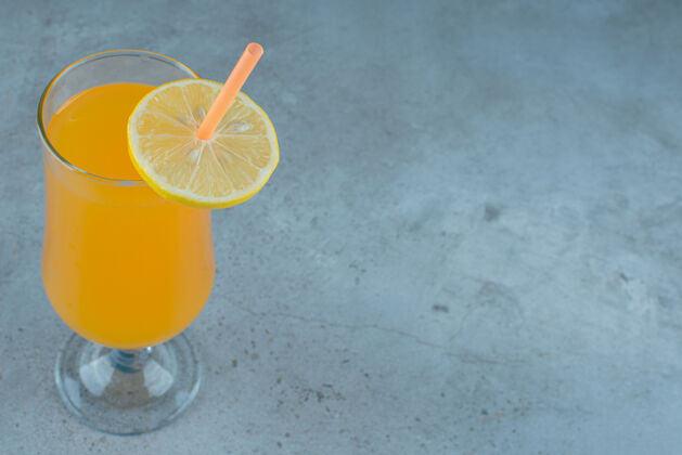 玻璃美味的橙汁加柠檬片和稻草切片冷液体