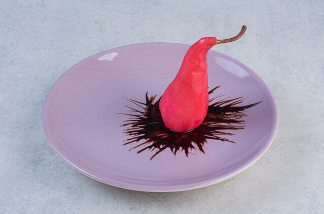 梨紫罗兰色盘上的巧克力红梨饮食产品服务