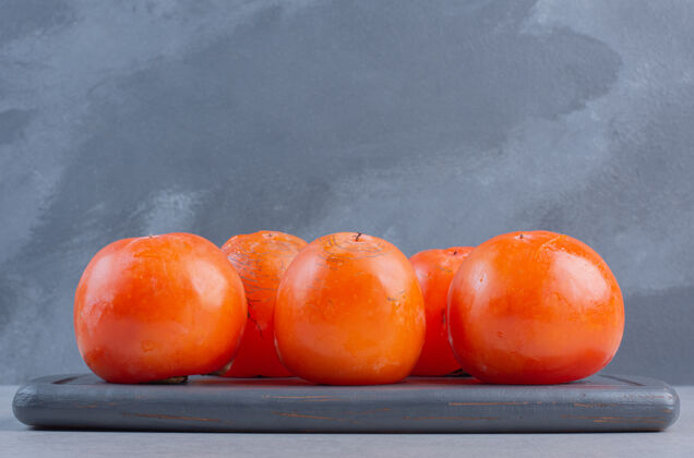 盘子熟透的桔子柿子的特写照片在木板上抗氧化剂亚洲营养