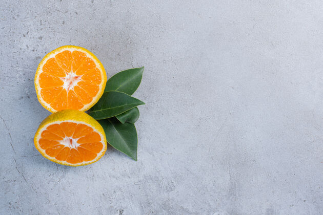 天然叶子和橘子片捆在一起放在大理石背景上营养风味美味
