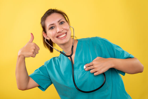 女医生正面图黄色背景 穿着医用衬衫 带听诊器的女医生视图医生黄色