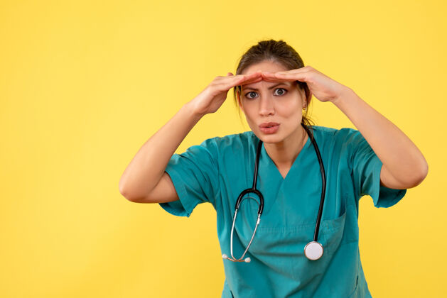 衬衫前视图黄色背景上穿着医用衬衫的女医生人前面医生