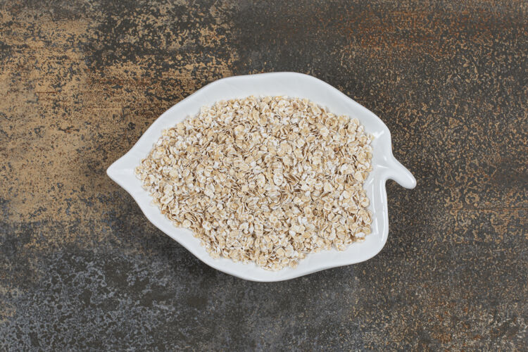 小麦美味的燕麦片放在叶子形状的盘子里卷燕麦种子水平