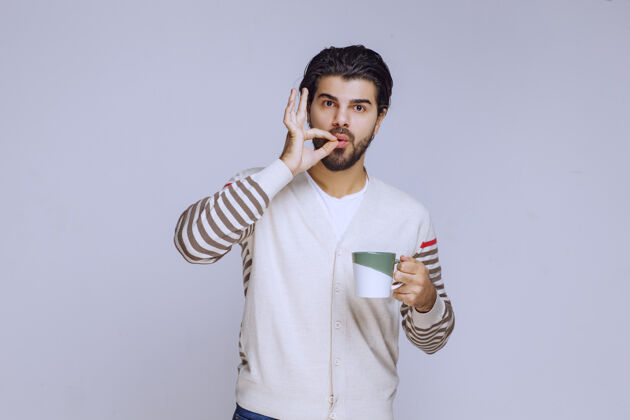 积极一个穿着白衬衫的男人拿着一个咖啡杯享受着它人体模型成人聪明