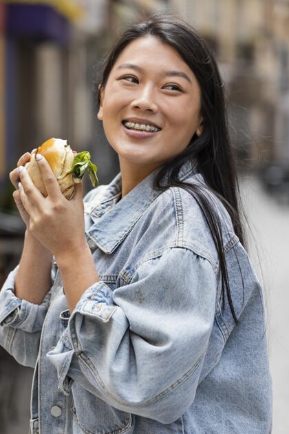 美味快乐的亚洲女人在户外吃汉堡食品顾客饥饿