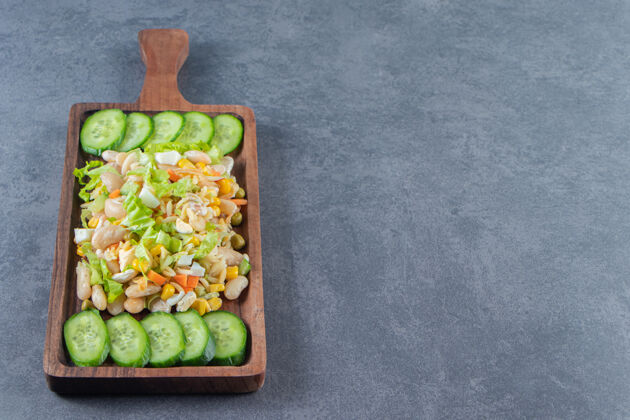 黄瓜蔬菜沙拉和黄瓜片放在木板上 大理石背景上背景白豆菜板