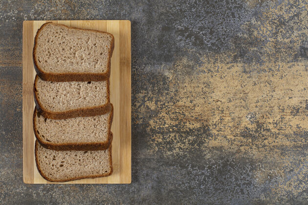 黑麦把新鲜黑麦面包片放在木板上面包皮早餐新鲜
