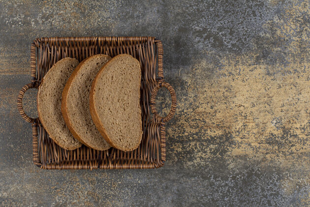 面包木篮里的黑麦面包片营养烘焙有机
