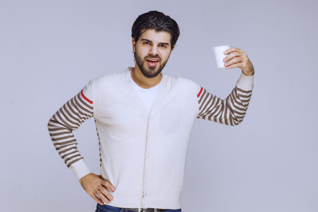 休闲一个穿着白衬衫的男人拿着一杯咖啡男性工人摄影
