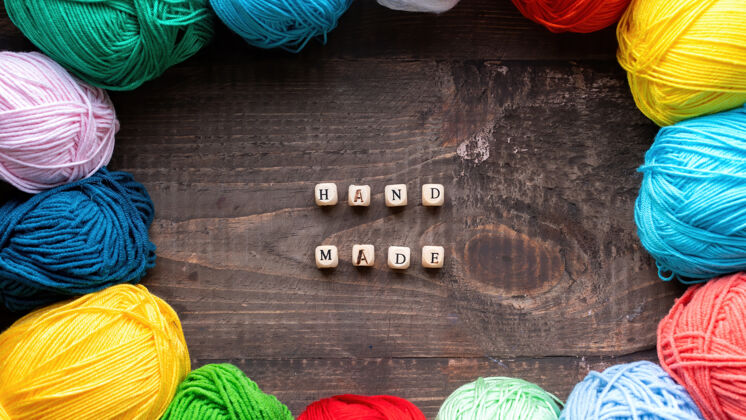 手工多种颜色的纱线球与木制字母组成的话 手工制作俯视图棉放松钩针