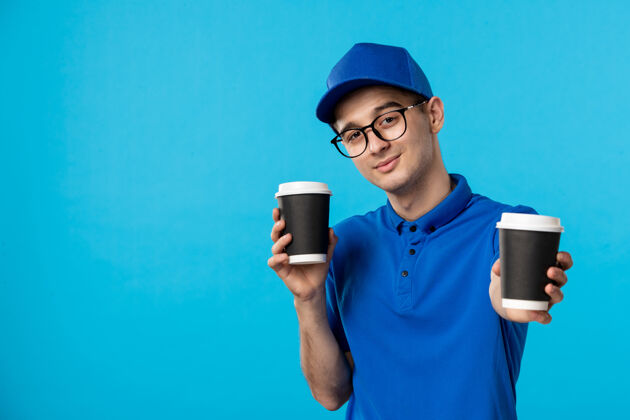 男信使身穿蓝色制服的男信使的正面图 蓝色上有咖啡服务制服咖啡