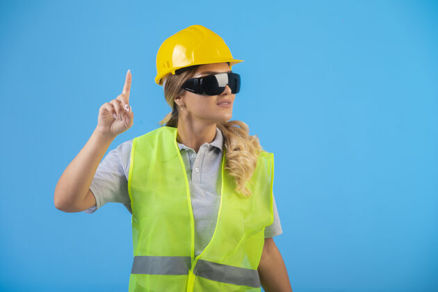 工作戴着黄色头盔和防护眼镜的女工程师面试工作演讲