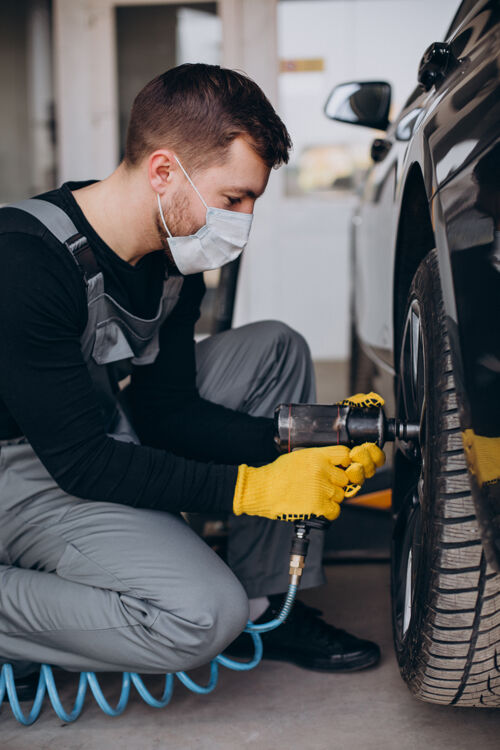 制服汽车修理工在车里换轮子问题修理工汽车机械师