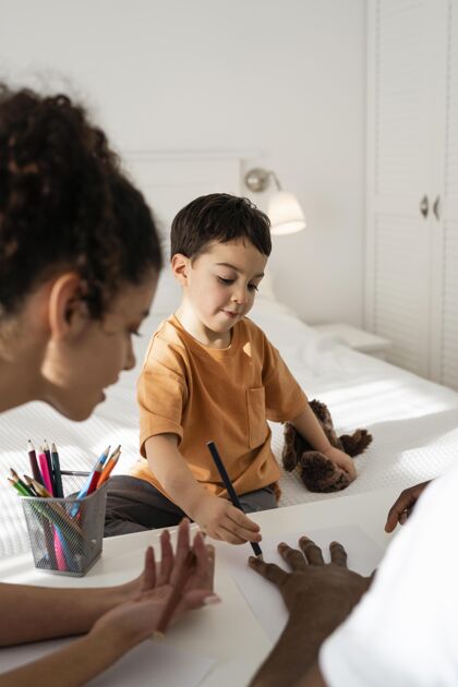 儿子可爱的小男孩在纸上画他爸爸的手快乐的家庭孩子熟悉