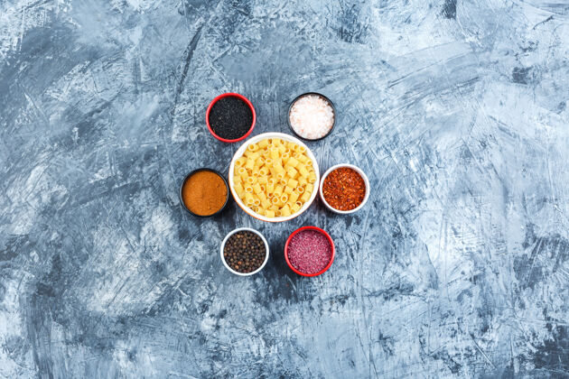 美食在灰色灰泥背景上的碗里放一些加香料的意大利面 顶视图罗勒奶酪意大利面