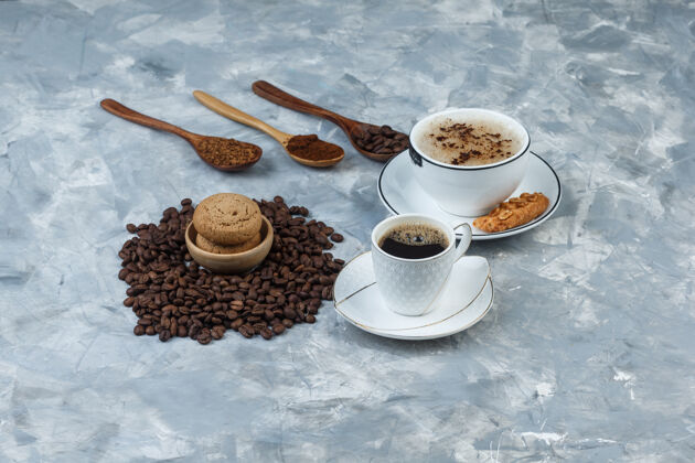 自然一套饼干 咖啡豆 磨碎的咖啡和咖啡杯在一个肮脏的灰色背景高角度视图新鲜的质地杯子