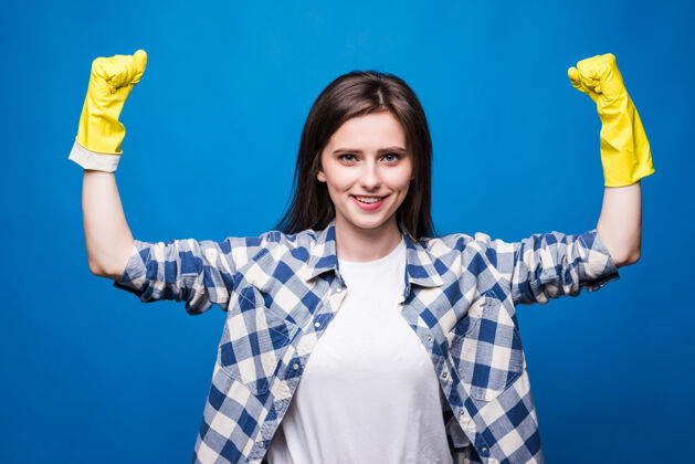 二头肌强壮的年轻女子举起双臂 露出肱二头肌 同时戴上黄色橡胶手套 在清洁过程中保护双手欢呼美丽日常