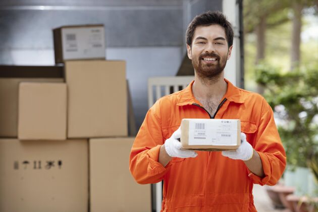 盒子微笑着的年轻送货员正在准备要送货的包裹拿着生意送货员