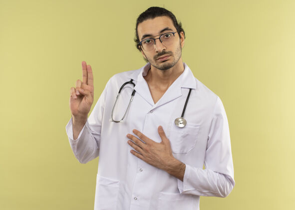 绿色年轻的男医生戴着眼镜 身穿白色长袍 听诊器显示姿势眼镜手势年轻