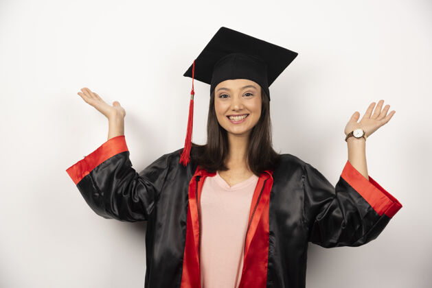 女人穿着礼服的应届毕业生在白色背景上举手站成功教育