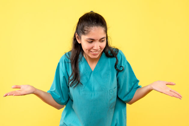 护士前视图微笑着身着制服的女医生在黄色孤立的背景上张开双手前面医生女医生