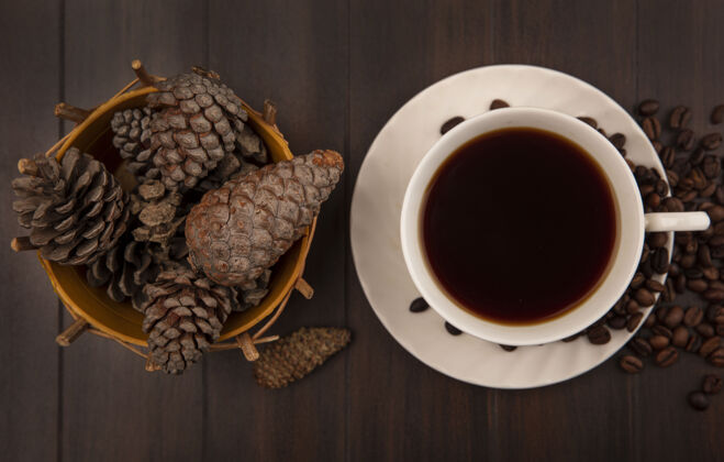 饮食一杯咖啡的顶视图 松果放在木桶上 咖啡豆被隔离在木制表面上松树美味配料