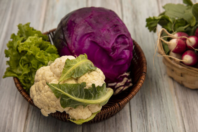 萝卜健康蔬菜的俯视图 如花椰菜紫色卷心菜和莴苣放在桶上 萝卜放在灰色木质表面的桶上农业生菜健康
