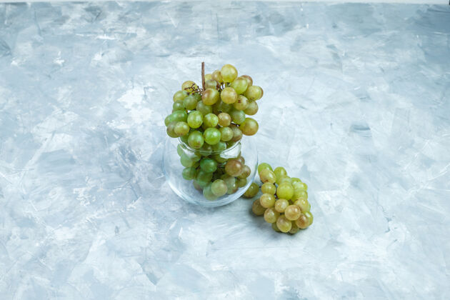 大绿色葡萄在一个玻璃罐在一个肮脏的灰色背景高角度看葡萄酒甜点饮食