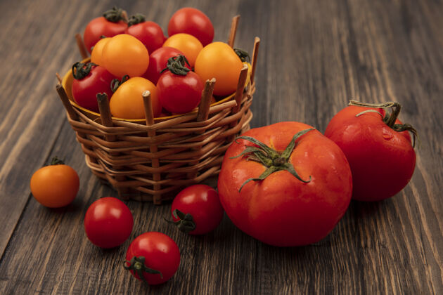 大红色和橙色樱桃番茄的顶视图在木桶上 大而软的番茄被隔离在木质表面上养殖营养木材