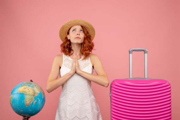 包年轻的女性游客与粉红色的包在轻墙上的正面视图前面头发时尚