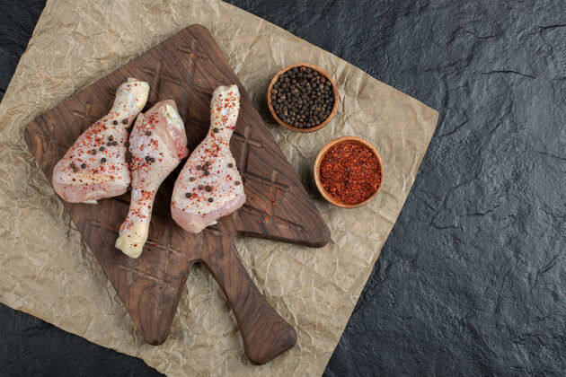 禽类顶视图生鸡腿和香料在木板上晚餐肉类烹饪