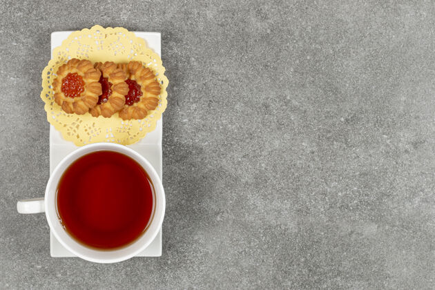 茶自制饼干加果冻和一杯茶放在白碟子上杯子果酱饼干