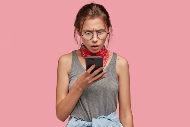 姿势愤怒迷惑不解震惊的女人盯着手机的画面长担心互联网