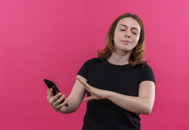不愉快一个年轻随意的女人拿着手机 在孤零零的粉色墙上做着“不”的手势女人手机随意