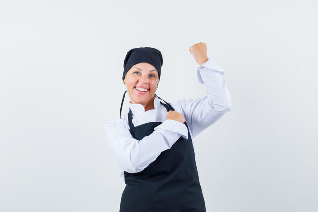 烹饪身着制服的女厨师 围裙展示获胜者的姿态 看起来很开心 正面视图模特成人围裙