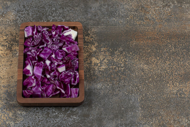 美味把切碎的红卷心菜放在托盘上 放在大理石表面蔬菜生的托盘