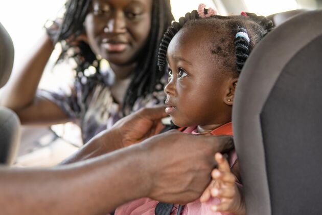 非洲父亲把女儿放在儿童车的椅子上孩子女孩可爱