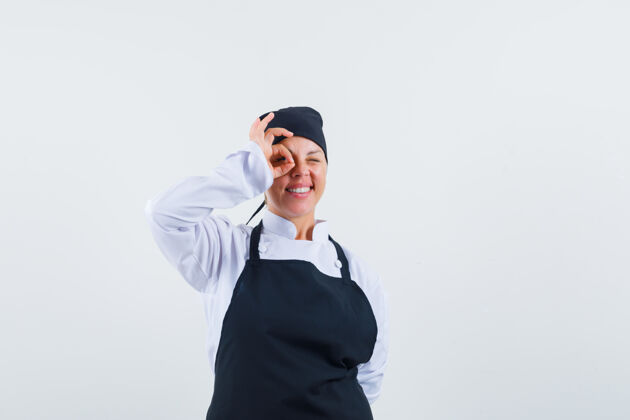 成人女厨师穿着制服 围裙 眼睛上显示ok标志 看起来很开心正视图快乐自信优雅