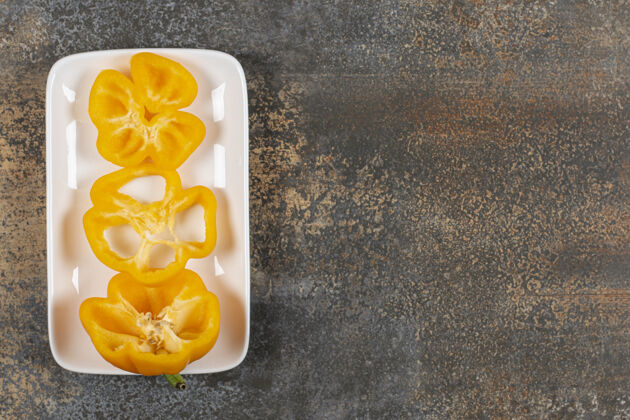 成熟甜椒放在大理石表面的盘子里美味盘子风味